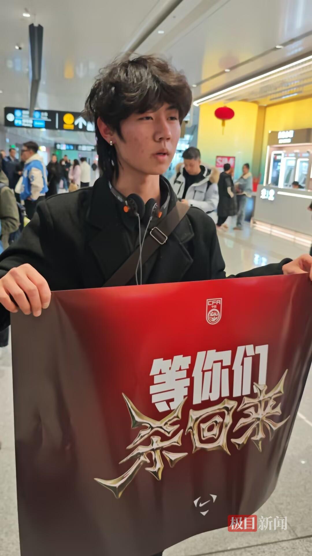 U23国足创历史最佳战绩后即将抵京，众多球迷穿“中国红”在机场迎接，有廊坊球迷手持李昊海报等候：他的表现毋庸置疑
